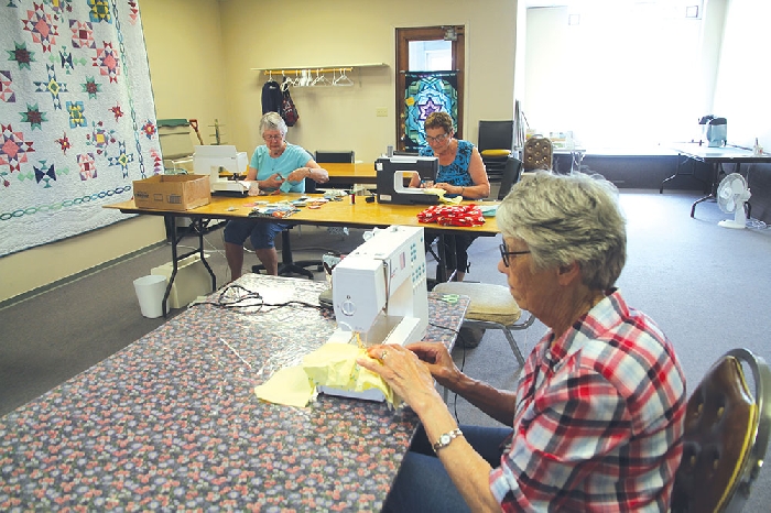 Some of the comfort quilters working on bags and receiving blankets for True North Aid.