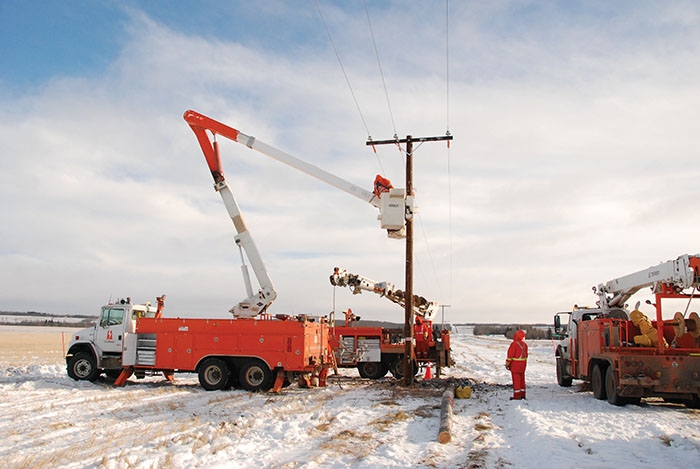 SaskPower crews inspecting and repairing power poles.