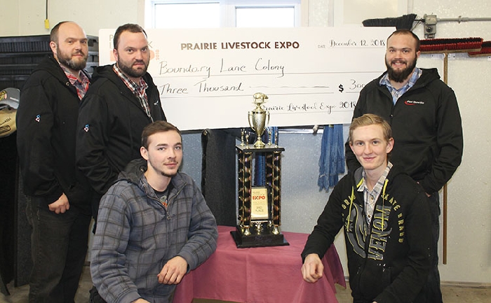 Above are some of the Boundary Lane Colony hog barn crew with their trophy and cheque. In back from left are Ken, Clinton, and Bryan Kleinsasser. In front are Mateo and Jesse Kleinsasser.