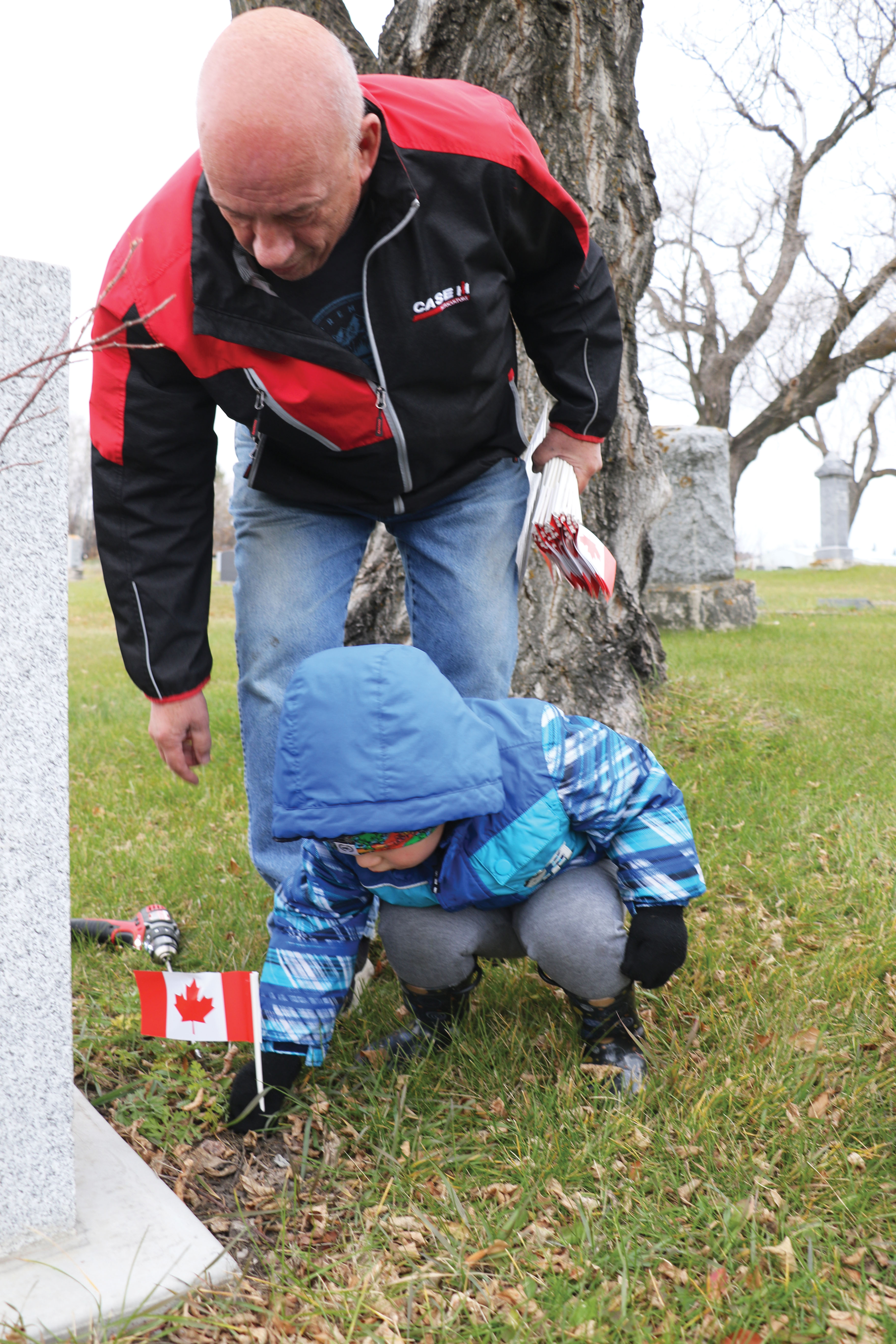 Beau Beckett placing a flag while Brian Beckett watches.