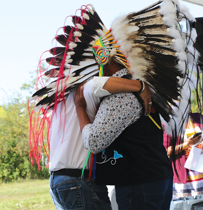 Chief Jonathan Pasap and former chief Nathan Pasap embrace one another.