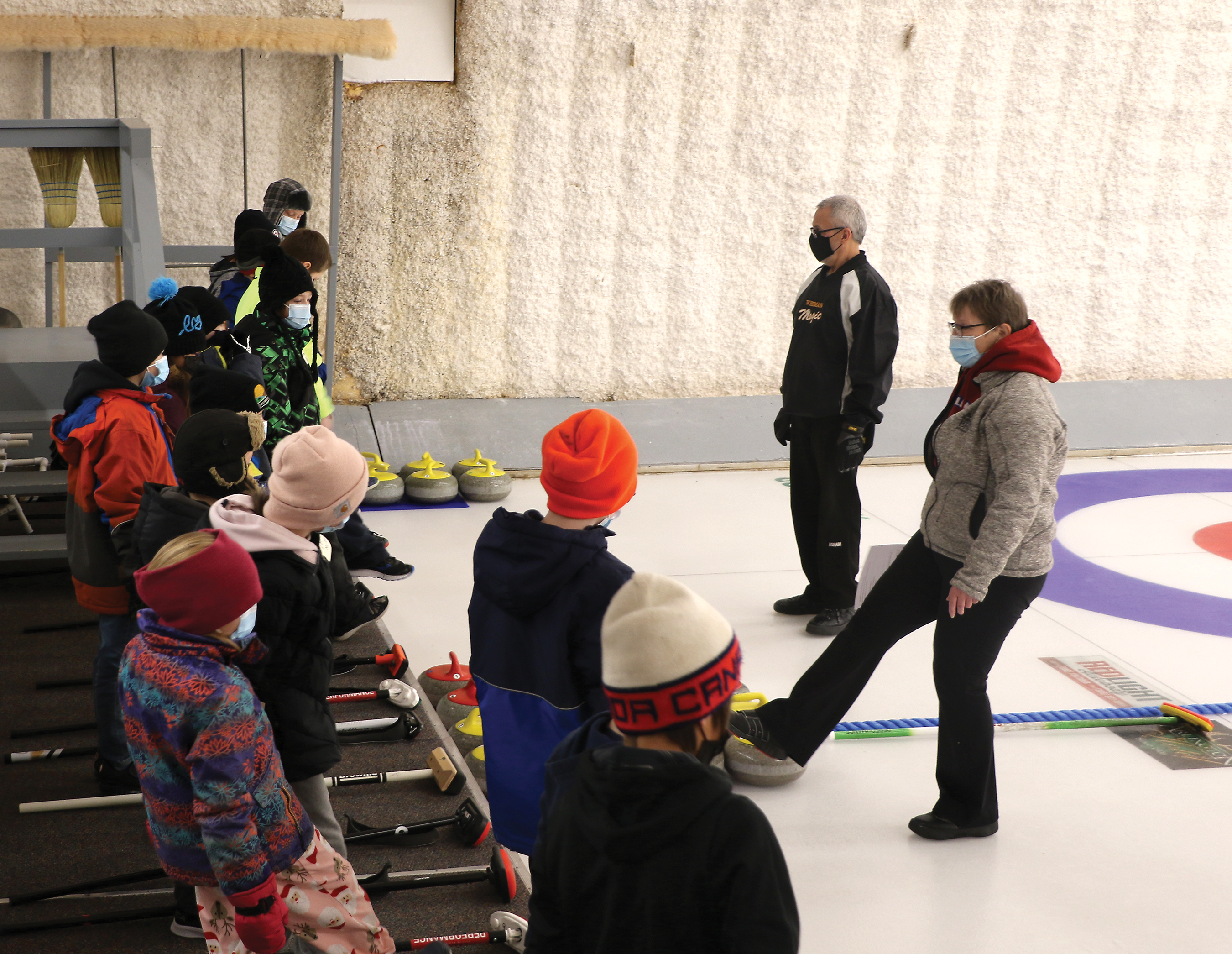 Curling instructor Barb Swallow demonstrating how to balance your feet on the ice to grades three and four students from Maryfield School.