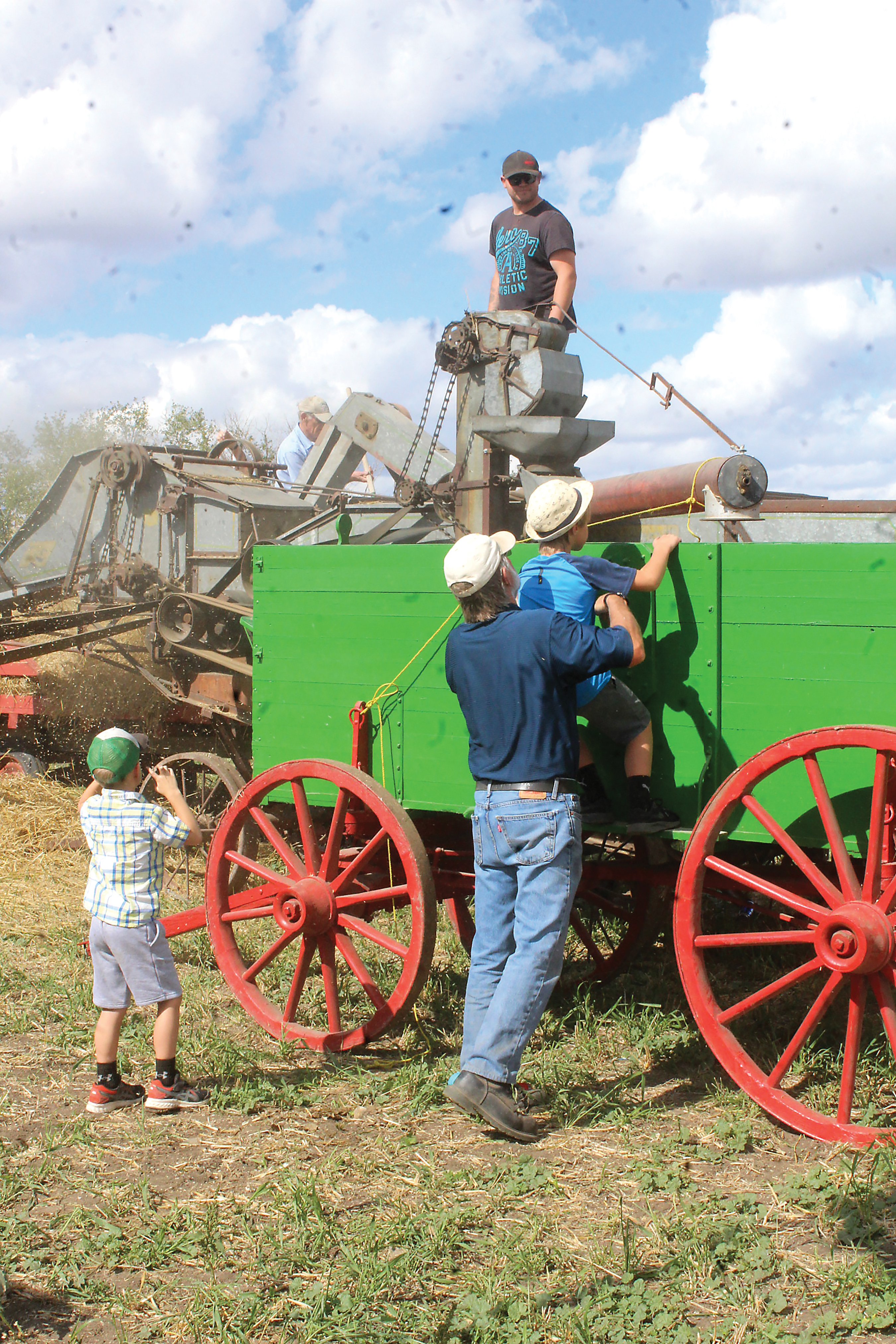 Henri being helped by his father to take a look into the grain wagon.