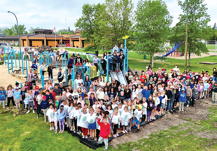 Students at MacLeod School on a new play structure that has been built at the school. The school was fundraising for the new structure for a couple of years, and a new provincial program contributed the last $50,000 so that it could be built this year. Volunteers were busy for a week installing the new playground and the kids are giving it rave reviews.