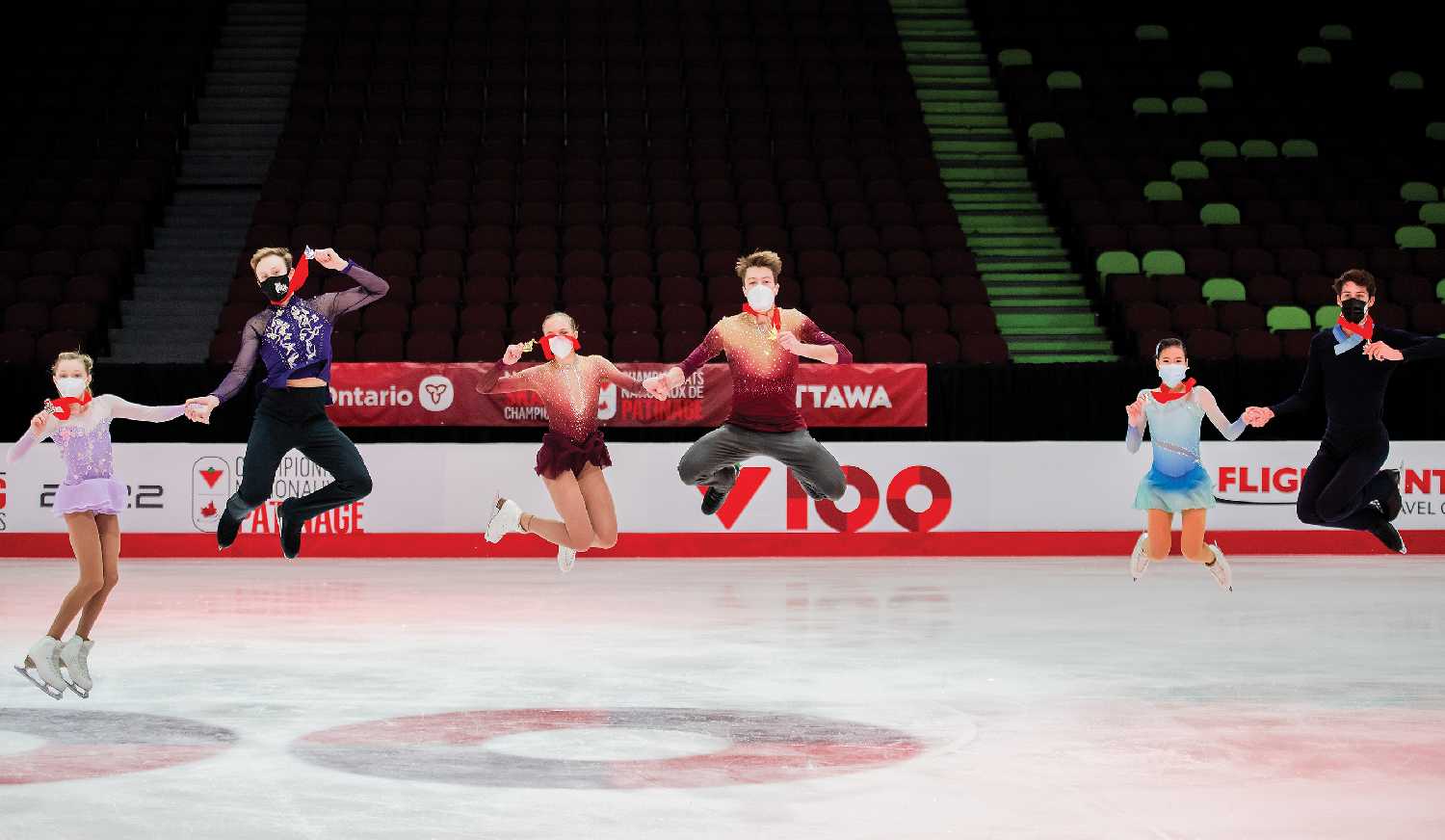 Marty Haubrich and Summer Homick, at far left, jumping to celebrate their silver medals in Junior Pairs at Skate Canada Nationals, along with the first and third place winners.