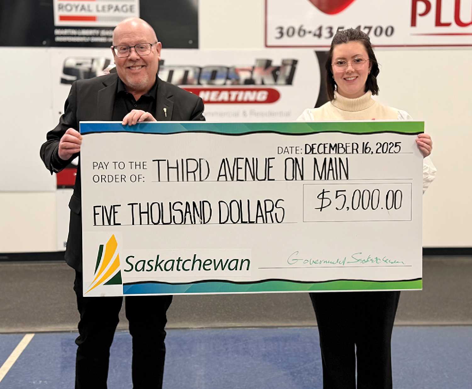 Moosomin Chamber President Kevin Weedmark presenting the Young Entrepreneur Bursary to Tia Cedarstrand with Third Avenue on Main in Moosomin.