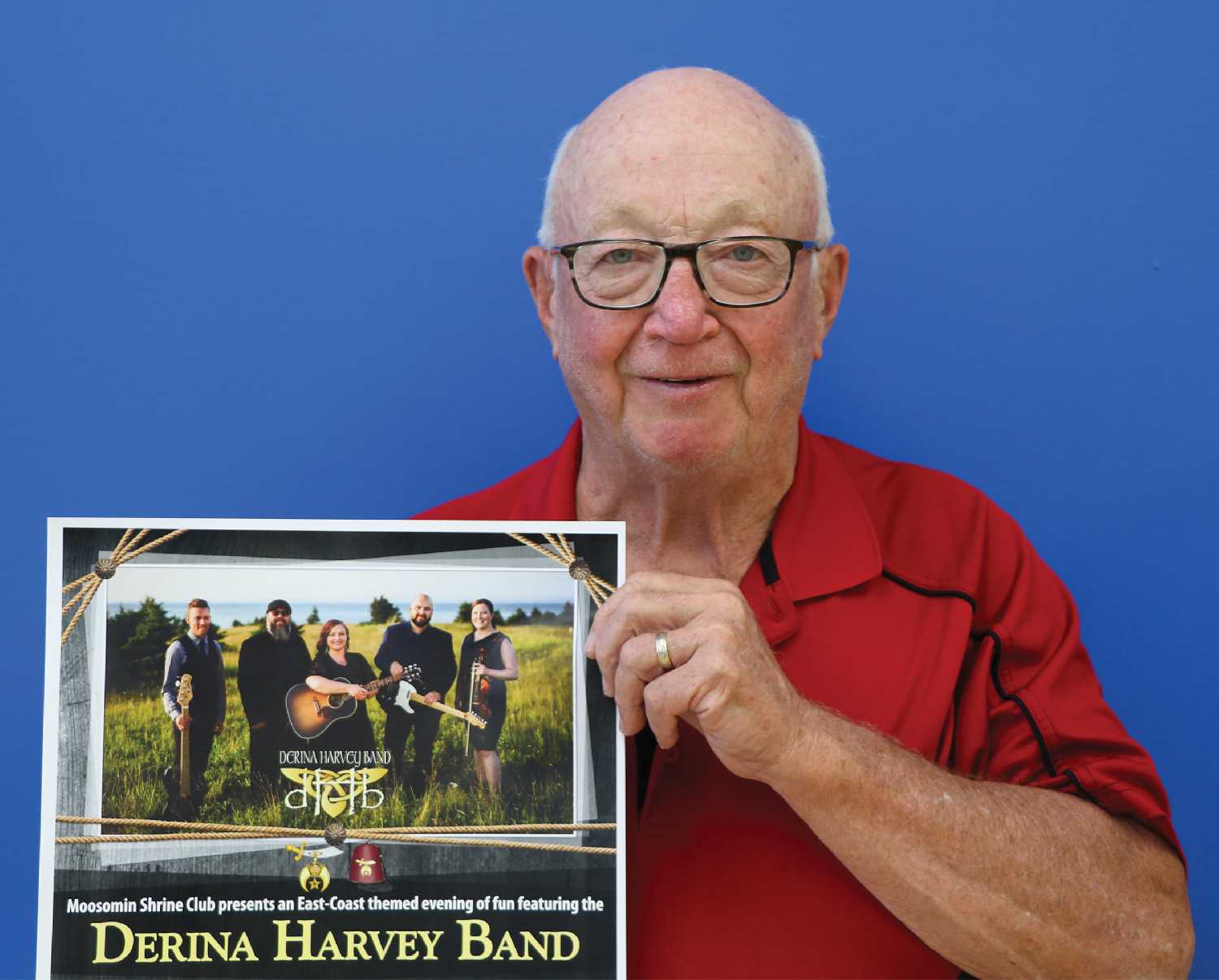 Bill Thorn holds up the poster for the Derina Harvey Band concert.